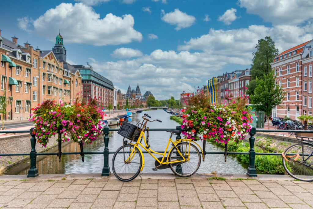 Bicycle parked on a bridge spanning a canal in Amsterdam, Netherlands