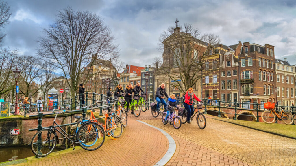 Locals and tourists biking in the historic center of Amsterdam, The Netherlands