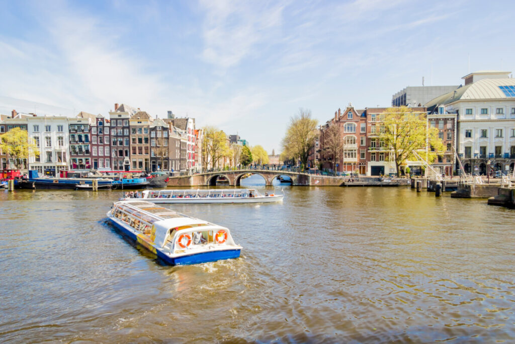 Panoramic view of boats cruising the canals of Amsterdam, Netherlands