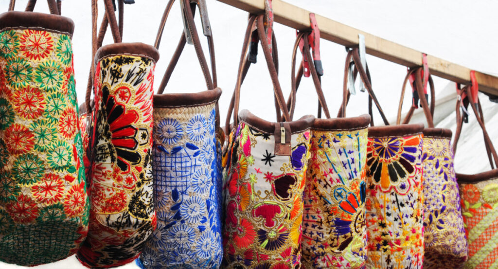 Close-up of the hanging colorful embroidered bags at a market stall in Amsterdam, Netherlands