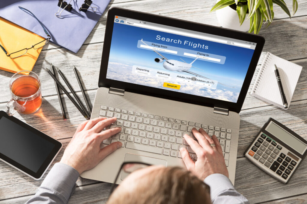 Man using laptop to search and book flight online