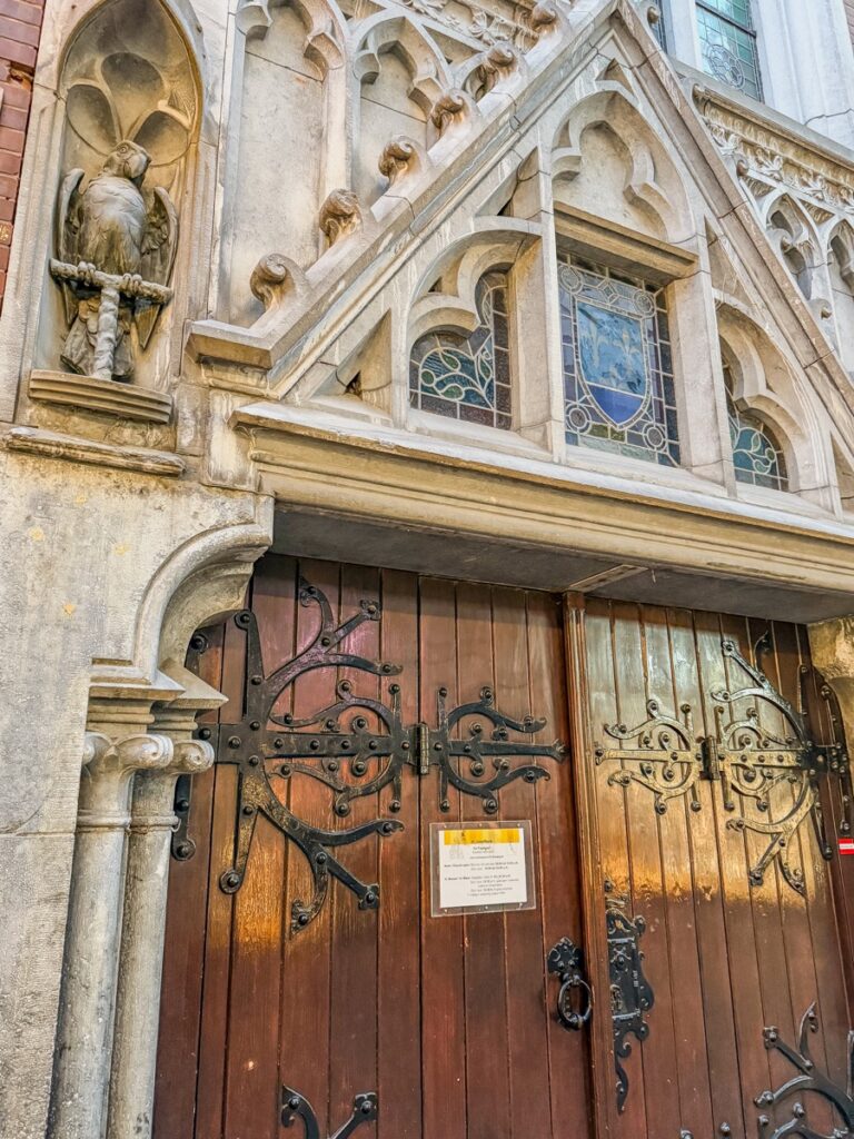 Entrance of De Papegaai, Amsterdams historic St. Joseph Church, featuring Gothic architecture.