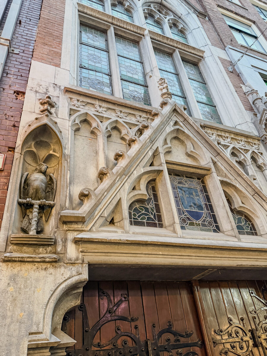 Gothic facade of De Papegaai, St. Joseph Church, Amsterdam with intricate stonework and stained glass.