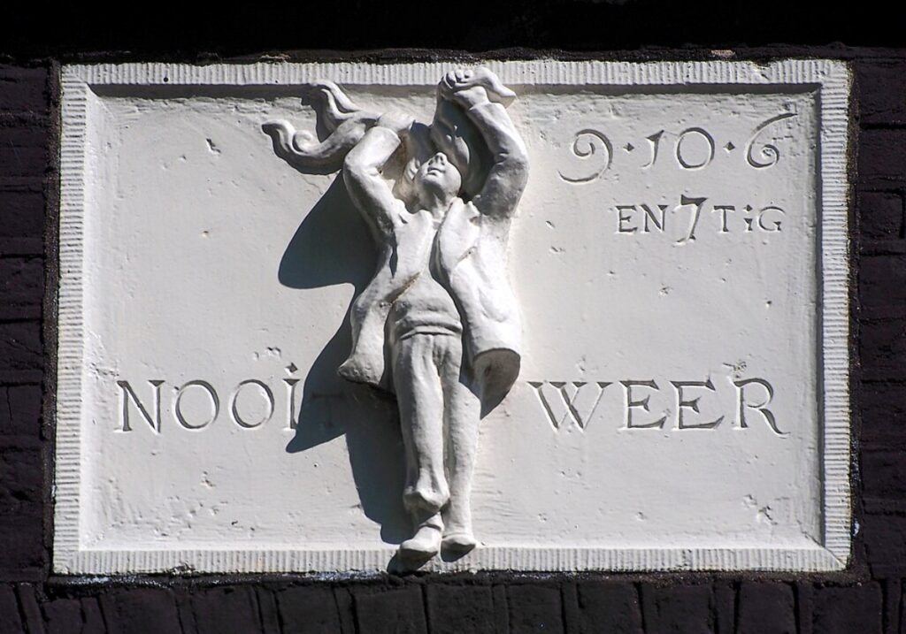 Gable stone at Prinsengracht 9 in Amsterdam inscribed with "Nooit Weer" (Never Again) in elegant lettering.
