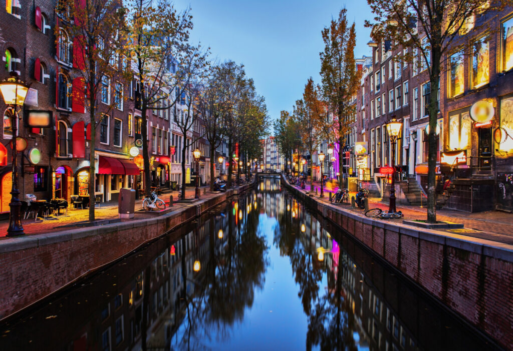 Night lights, canal view, and the establishments of the Red Light District, De Wallen in Amsterdam, Netherlands