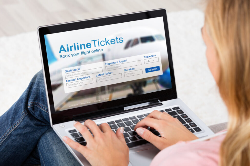Woman using laptop to search and book plane tickets online