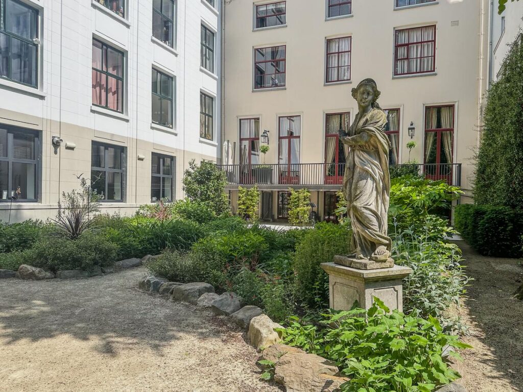 Tranquil garden at the Museum of the Canals, Amsterdam, with classical sculpture and greenery