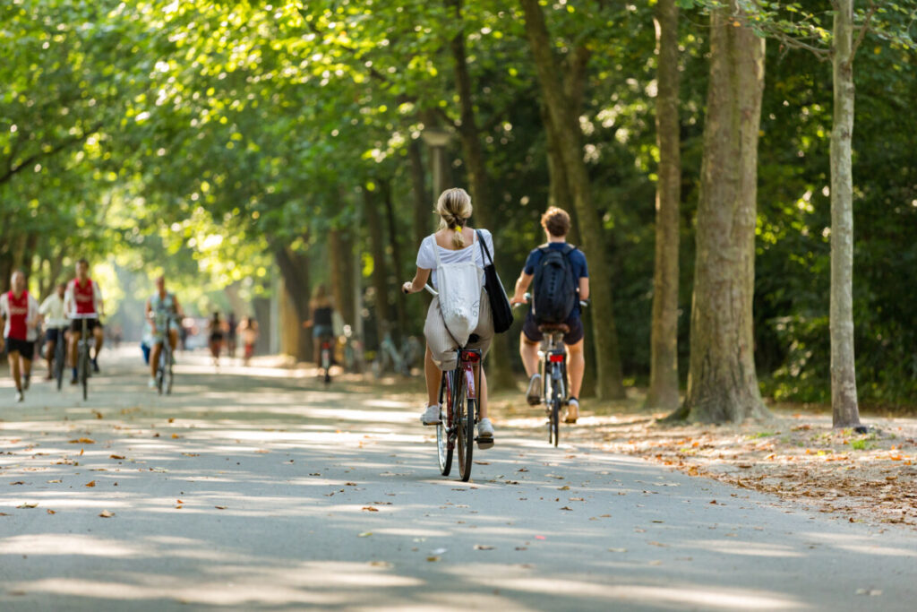 Tourists and locals biking and exploring Vondelpark in Amsterdam, Netherlands